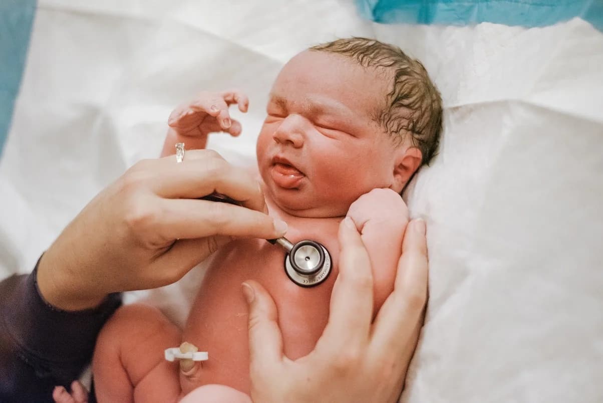 Mother lifting her baby to her chest with trembling hands