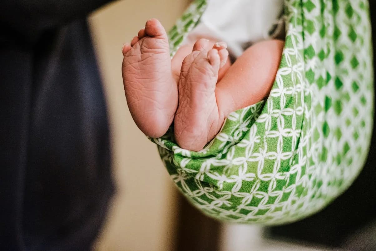 Father's hands cradling his newborn daughter