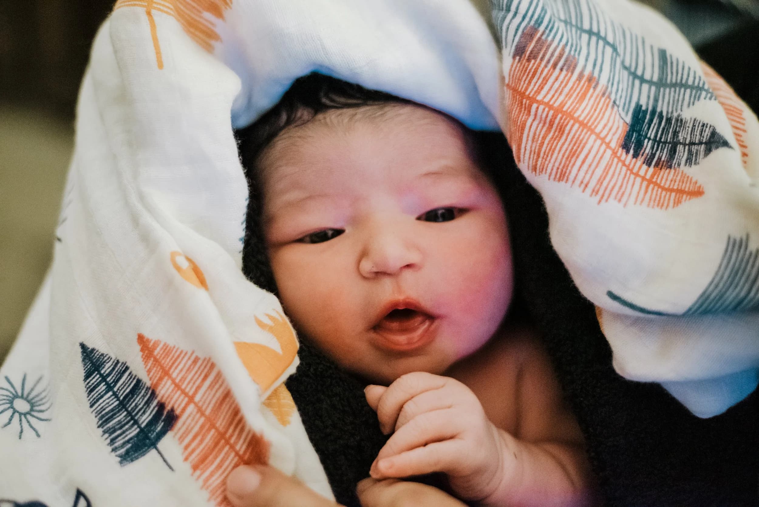 Tiny hand grasping a finger with surprising strength