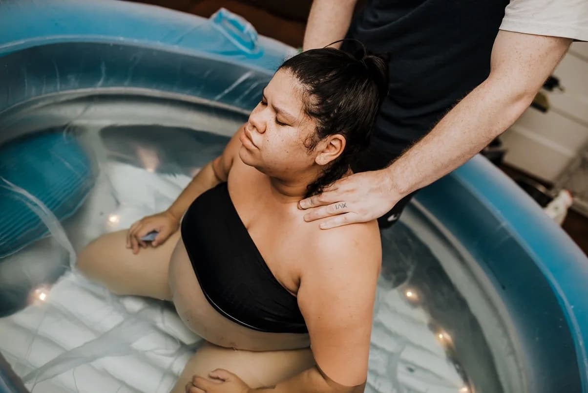 Midwife monitoring with calm expertise as pushing begins