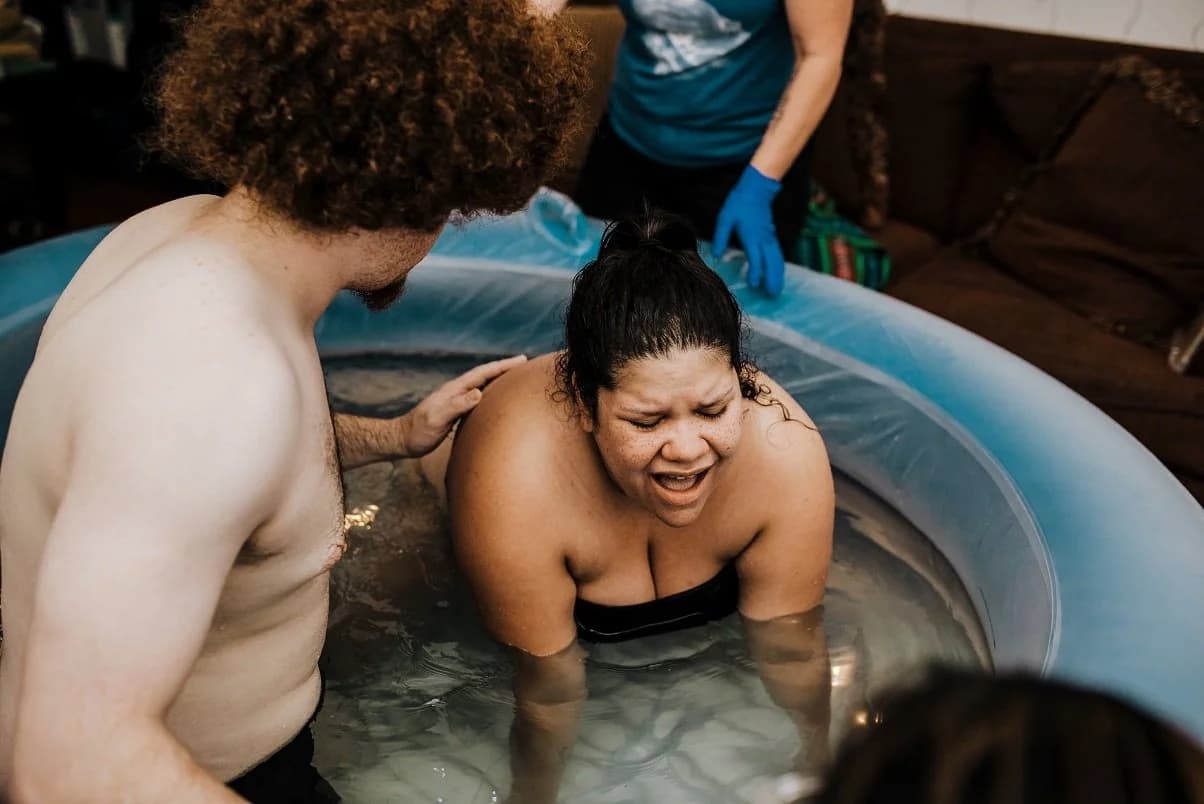 Lifting her baby from the water to her chest