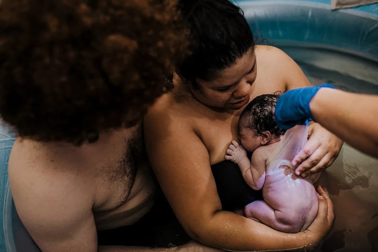 New family together in the birth pool, still processing